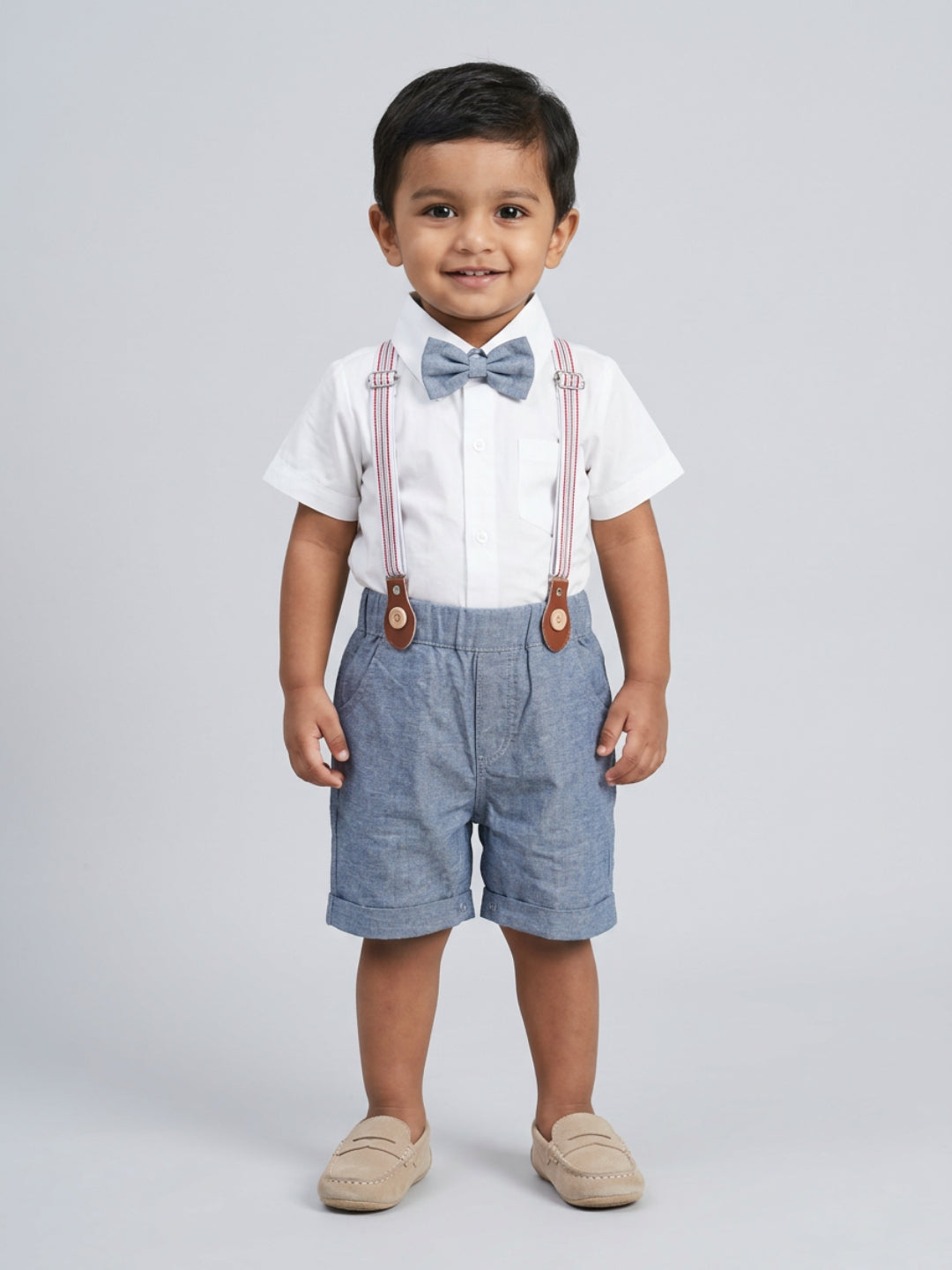 Camisa blanca de niño Biglilpeople con pajarita clásica y pantalones cortos azules con tirantes