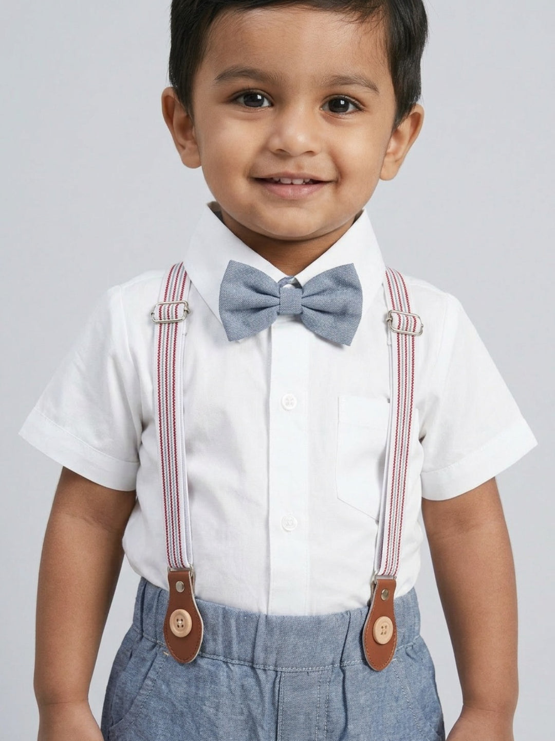 Camisa blanca de niño Biglilpeople con pajarita clásica y pantalones cortos azules con tirantes