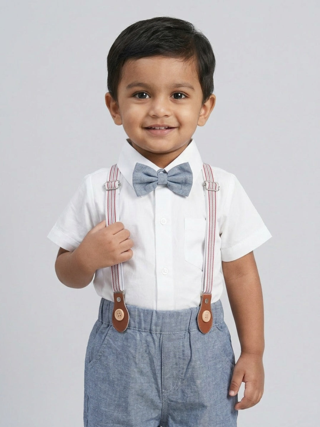 Camisa blanca de niño Biglilpeople con pajarita clásica y pantalones cortos azules con tirantes